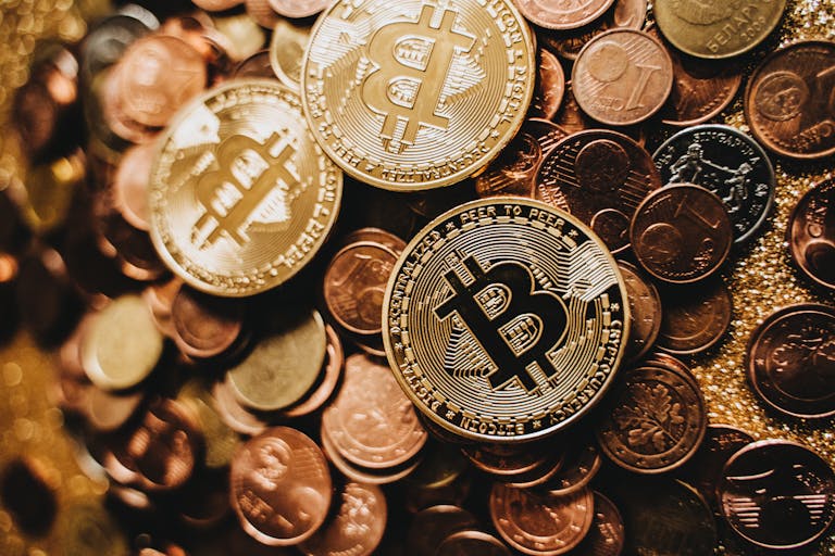 A detailed close-up of shiny bitcoins and assorted coins symbolizing digital currency and wealth.