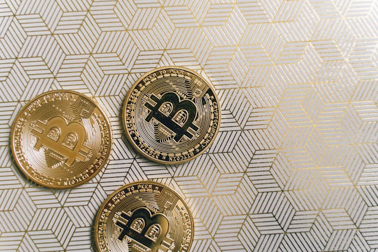 Close-up of Bitcoin cryptocurrency coins on a geometric patterned background, showcasing innovative digital currency.
