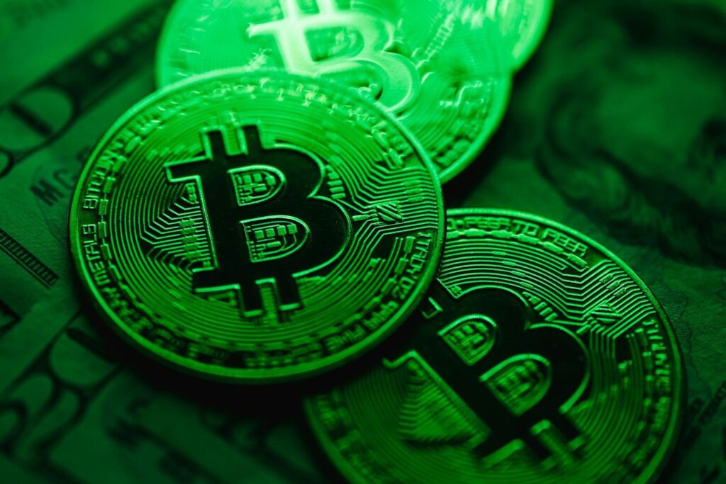 Close-up image of shiny Bitcoin coins with a digital green light effect, symbolizing blockchain technology.