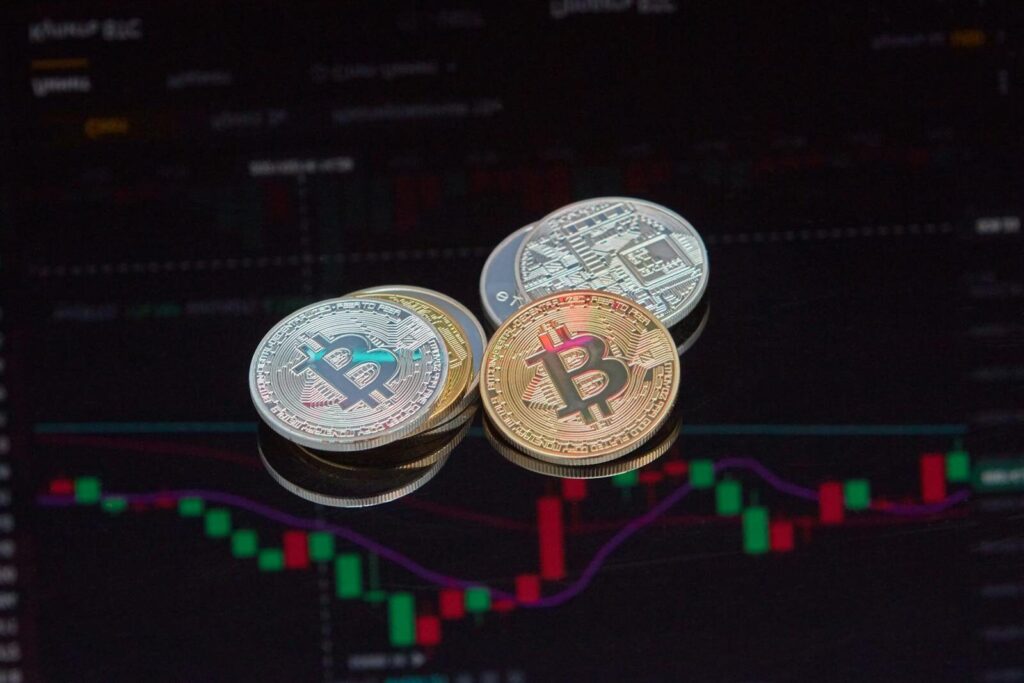 Close-up view of Bitcoin coins on a stock market chart background representing cryptocurrency trading.